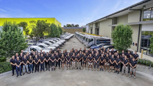 A team posing in front of a building.