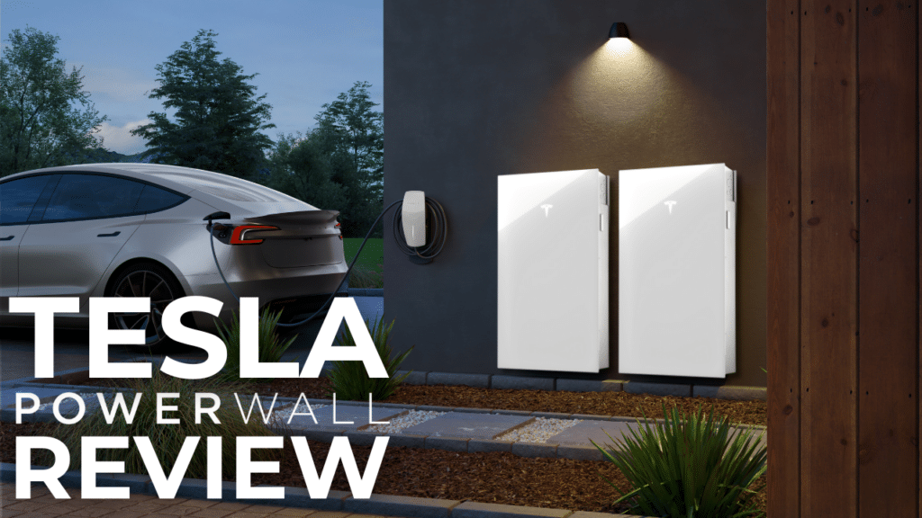 A Tesla car is parked next to a charging station, with two Tesla Powerwall units mounted on a wall. The image text reads "TESLA POWERWALL REVIEW.