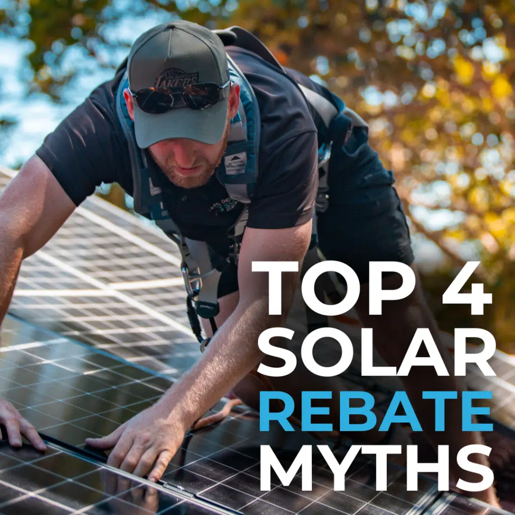 A person in a harness and cap is installing solar panels on a roof. Text on the image reads "Top 4 Solar Rebate Myths.