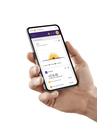 A hand holding a smartphone displaying a solar analytics app with graphs and financial data.