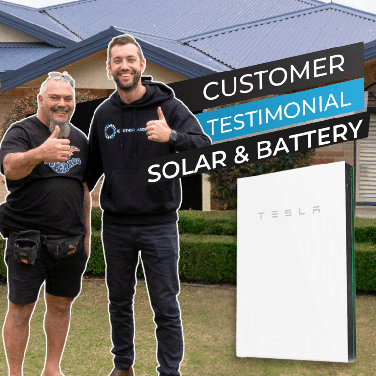 Two smiling men standing in front of a house with a Tesla solar battery visible. The text reads "Customer Testimonial Solar & Battery." One man is giving a thumbs-up gesture.